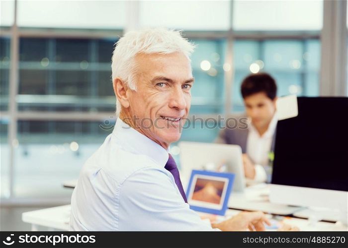 Businessman in office smiling at camera. Success and professionalism in person