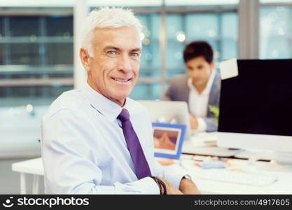 Businessman in office smiling at camera. Success and professionalism in person