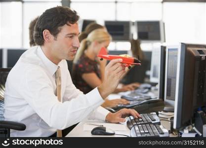 Businessman in office space with a toy airplane