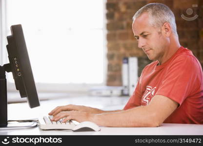 Businessman in office typing on computer