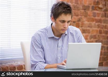 Businessman in office typing on laptop