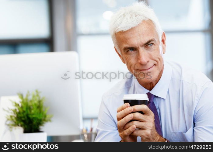 Businessman in office with a cup. Time for coffee