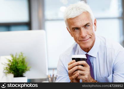 Businessman in office with a cup. Time for coffee