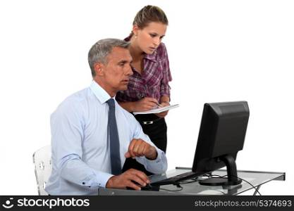 businessman in office with computer and young female assistant