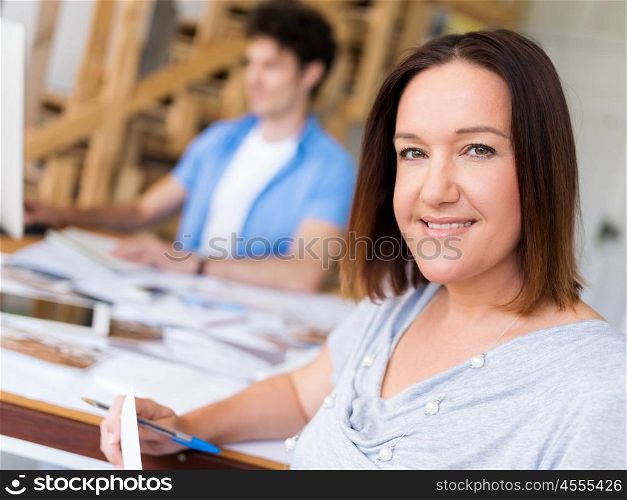 Businessman in office with her collegue at background