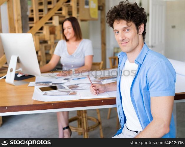 Businessman in office with his collegue at background