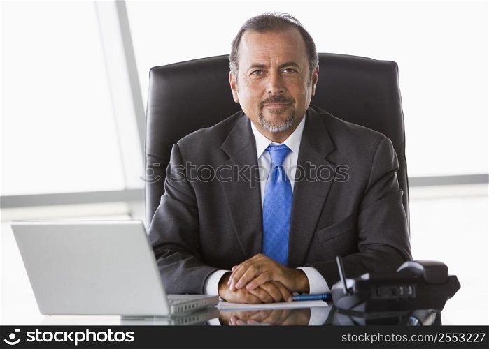 Businessman in office with laptop (high key/selective focus)