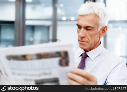 Businessman in office with newspaper. Learning the news