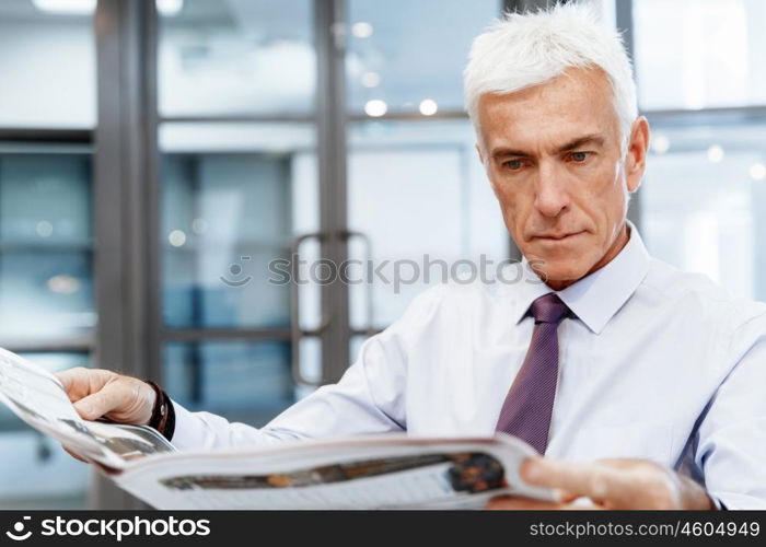 Businessman in office with newspaper. Learning the news