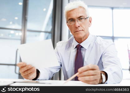 Businessman in office working with papers. New plans and new decisions