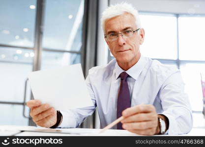 Businessman in office working with papers. New plans and new decisions