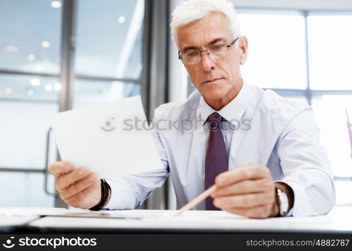 Businessman in office working with papers. New plans and new decisions