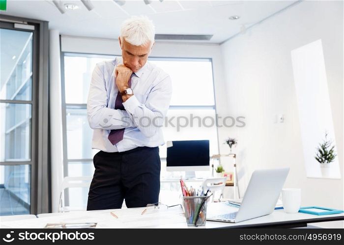 Businessman in office working with papers. New plans and new decisions