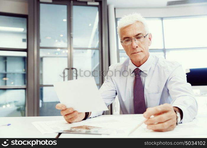 Businessman in office working with papers. New plans and new decisions