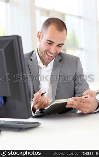 Businessman in office writing on agenda