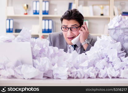 Businessman in paper recycling concept in office