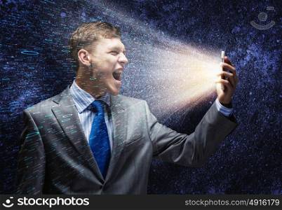 Businessman in rage. Aggressive businessman screaming fiercely in mobile phone