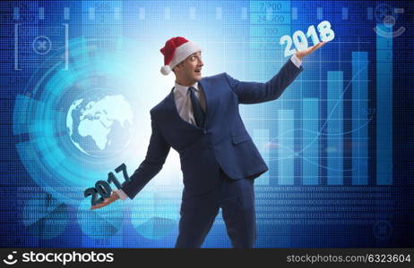 Businessman in santa hat holding 2017 and 2018