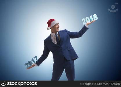 Businessman in santa hat holding 2017 and 2018. The businessman in santa hat holding 2017 and 2018