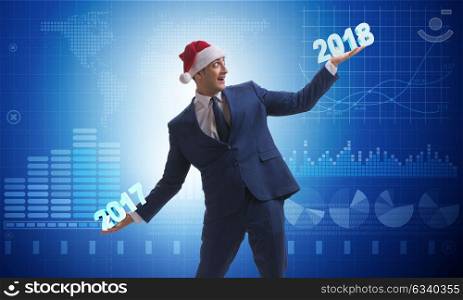 Businessman in santa hat holding 2017 and 2018