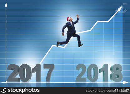 Businessman in santa hat jumping from 2017 to 2018. The businessman in santa hat jumping from 2017 to 2018