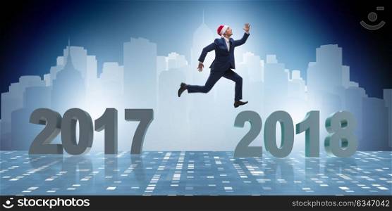 Businessman in santa hat jumping from 2017 to 2018