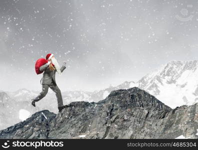 Businessman in Santa hat running with bag on back