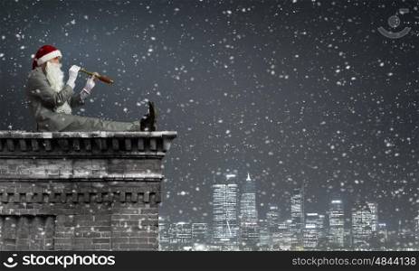 Businessman in Santa hat standing on top and looking in spyglass