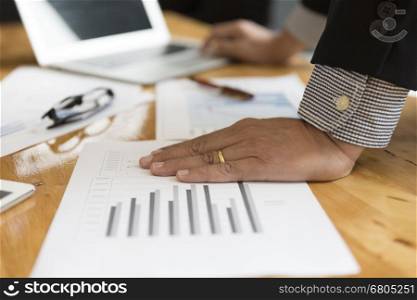 businessman in suit analyse with market analysis business chart document with computer