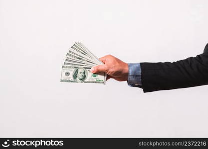 Businessman in suit holding several 100 dollar bills. Finance concept.