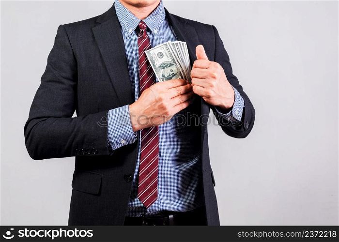 Businessman in suit holding several 100 dollar bills. Finance concept.