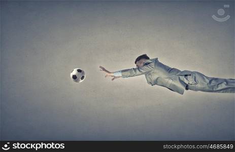 Businessman in suit jumping to hit soccer ball. Hit your goal