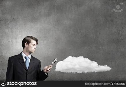 Businessman in suit looking through magnifying glass. Man with magnifier