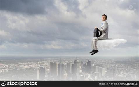 Businessman in suit sitting on cloud in isolation. Taking break from office