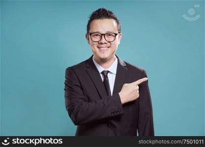 Businessman in suit smile and finger point to the right .