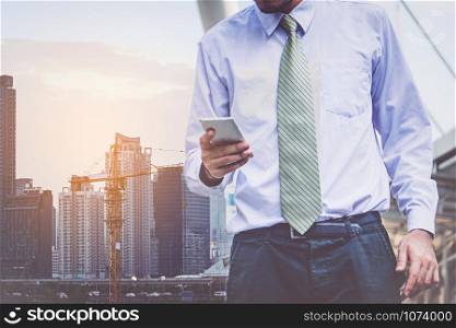 businessman in suit using smartphone at city