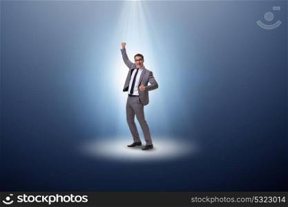 Businessman in the spotlight in business concept. The businessman in the spotlight in business concept