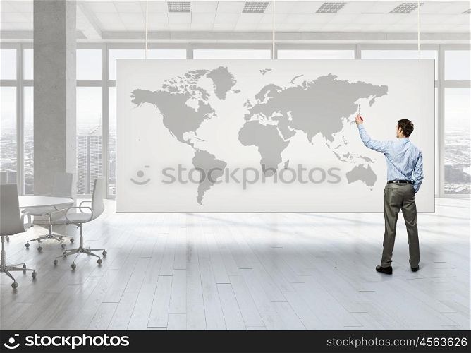 Businessman in top level office. Back view of elegant businessman against banner with business strategy plan