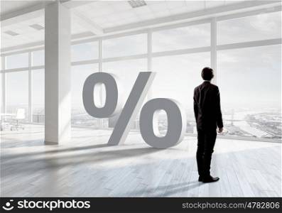 Businessman in top level office. Back view of elegant businessman against modern ofiice window