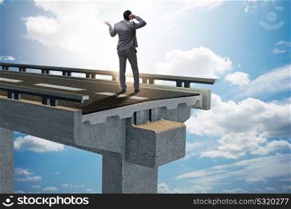Businessman in uncertainty concept with broken bridge