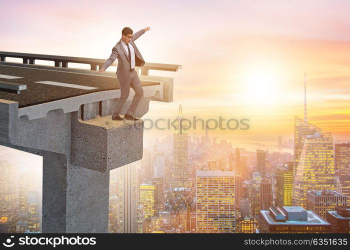 Businessman in uncertainty concept with broken bridge