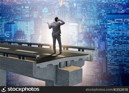 Businessman in uncertainty concept with broken bridge