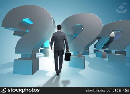 Businessman in uncertainty concept with question marks