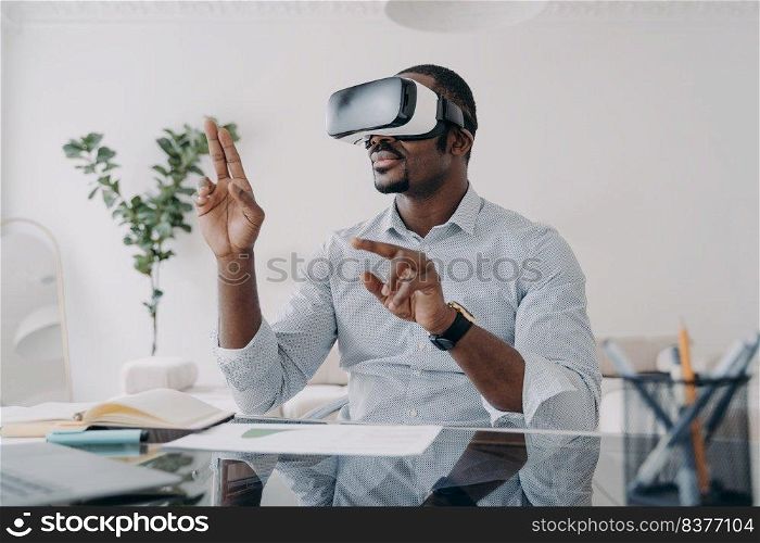 Businessman in vr headset clicks virtual buttons. Freelancer is working on design project. African american man in futuristic vr headset at home. Modern digital technology for business and creativity.. Businessman in vr headset clicks virtual buttons. Modern technology for business and creativity.