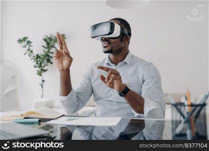 Businessman in vr headset clicks virtual buttons. Freelancer is working on design project. African american man in futuristic vr headset at home. Modern digital technology for business and creativity.. Businessman in vr headset clicks virtual buttons. Modern technology for business and creativity.