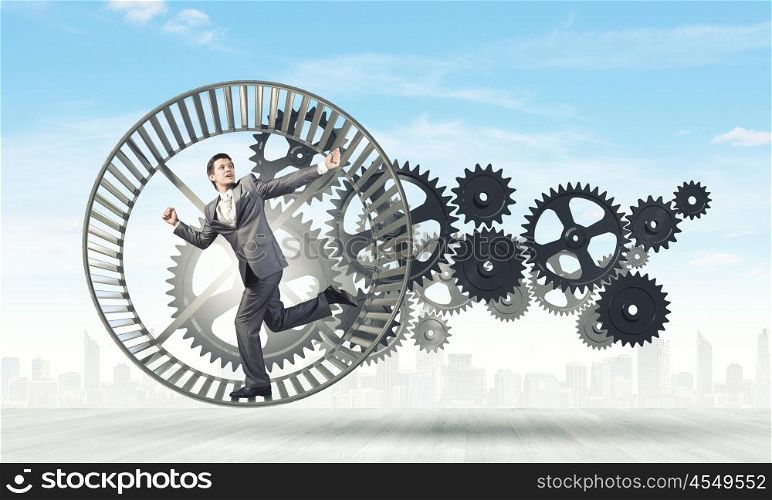Businessman in wheel. Young businessman in suit running in hamster wheel