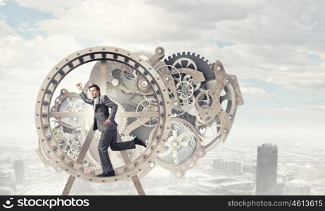 Businessman in wheel. Young businessman in suit running in hamster wheel