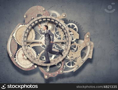 Businessman in wheel. Young businessman in suit running in hamster wheel