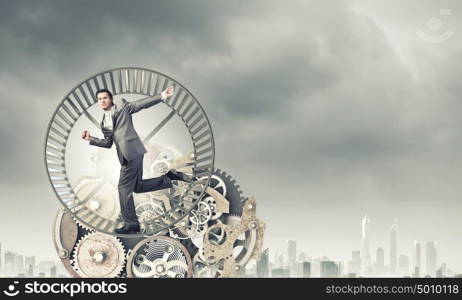 Businessman in wheel. Young businessman in suit running in hamster wheel