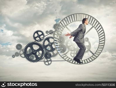 Businessman in wheel. Young businessman in suit running in hamster wheel